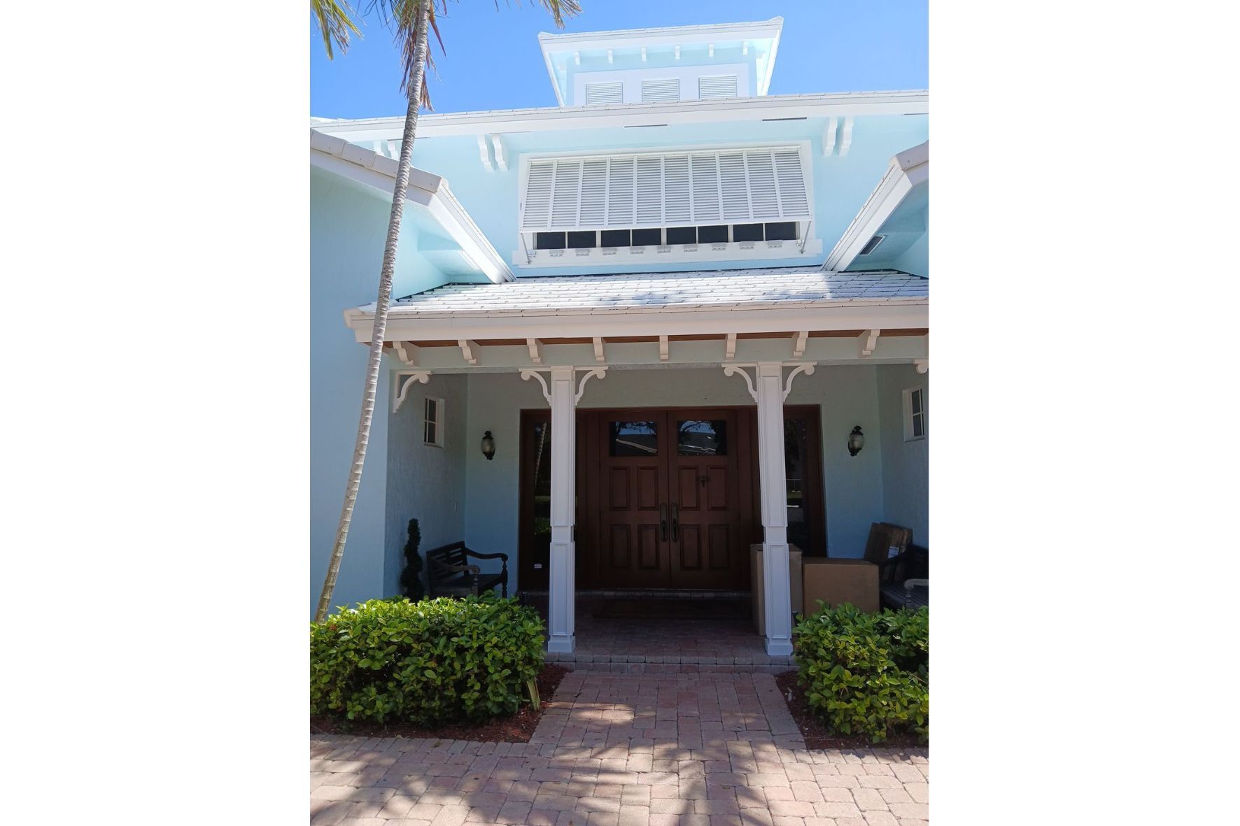 Exterior of florida home with white trim and wood front door